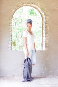 woman wearing white v-neck tee and ripped jeans while holding leather jacket