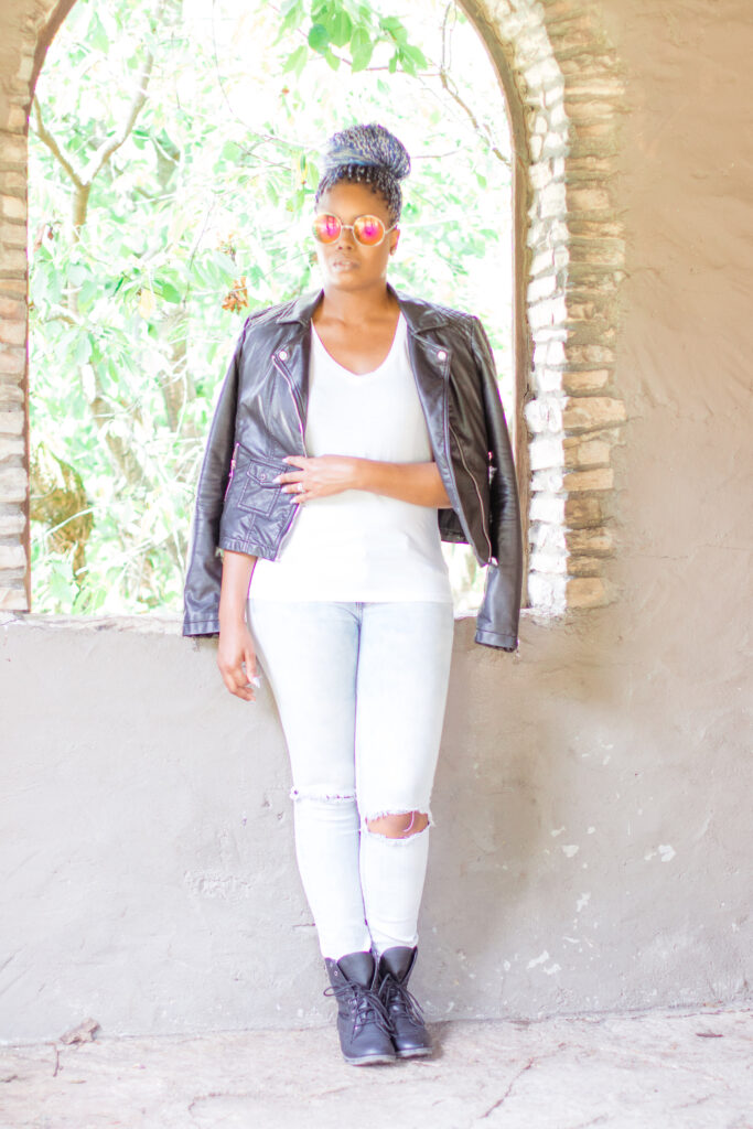 woman wearing ripped jeans, v-neck and leather moto jacket